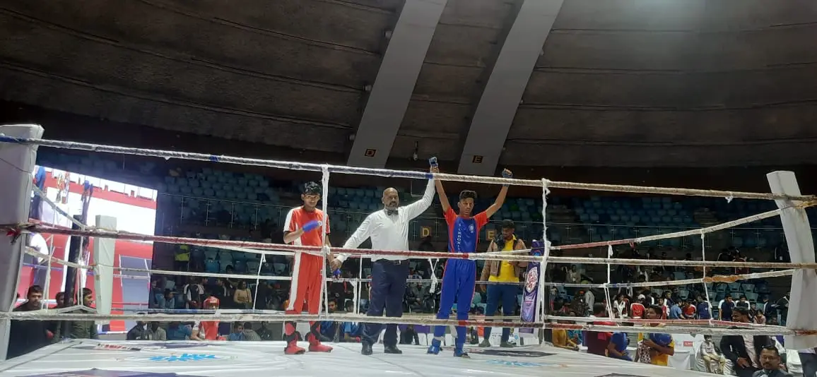 A bout result being announced in an indoor kickboxing arena