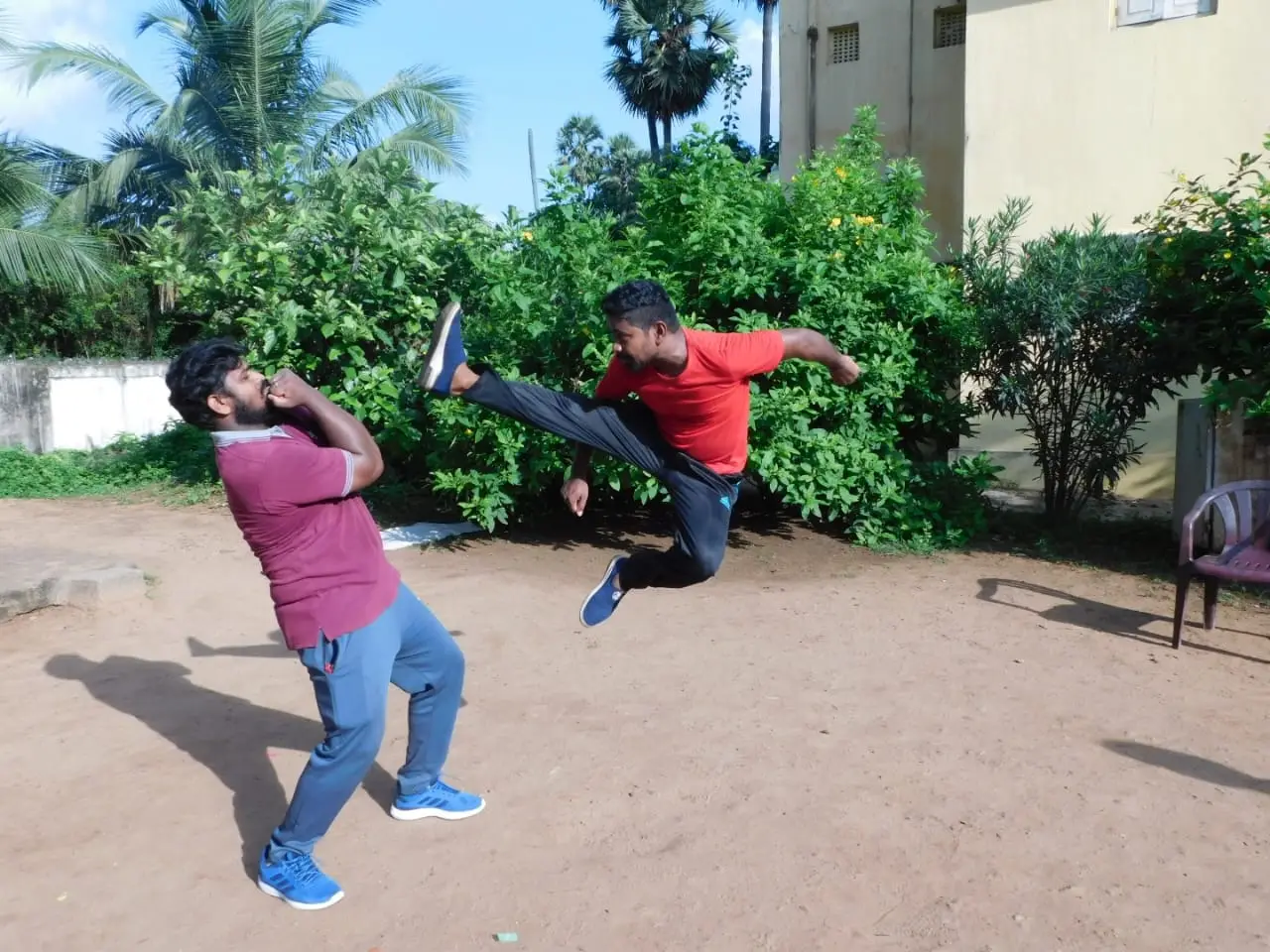 Flying kick drill in the club's sand yard, one student slipping under the kick
