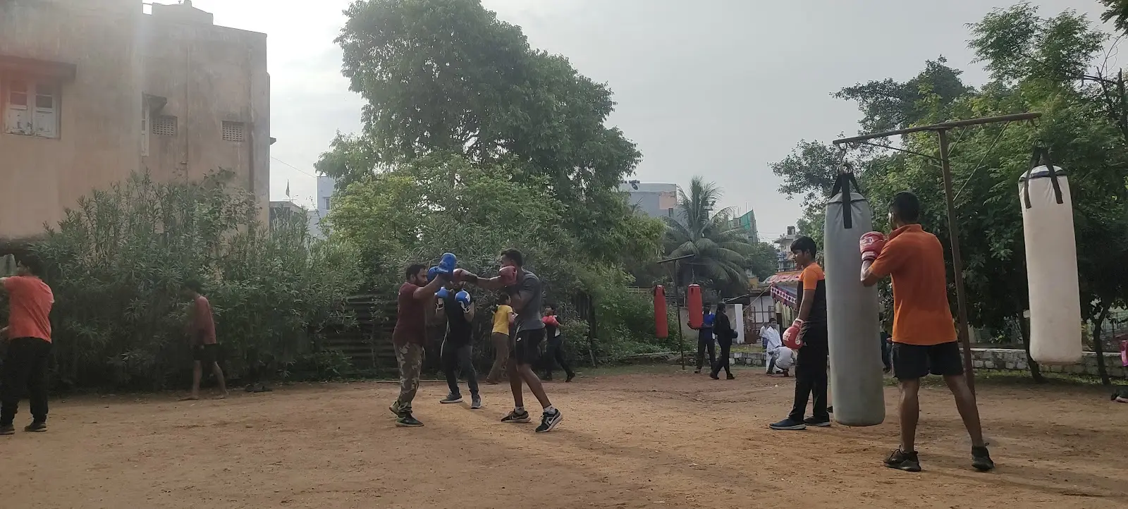 Students working pads and heavy bags across the club's open-air yard